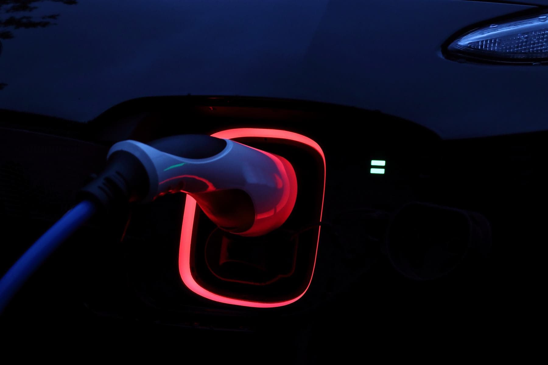 Carro elétrico recarregando à noite